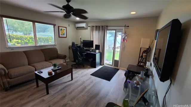 a living room with furniture a ceiling fan a flat screen tv and a window