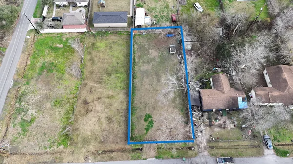 an aerial view of a house with a yard and large trees
