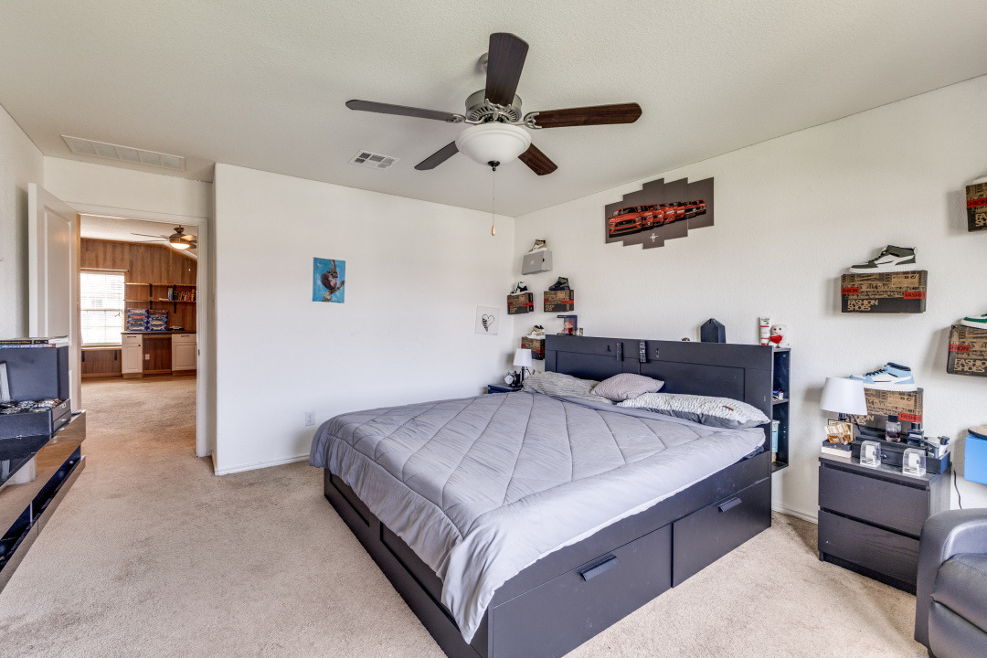 444 Major Lee Lane, Unit 14H Jarrell, TX 76537 - Photo 12 of 22 a bedroom with a bed and ceiling fan