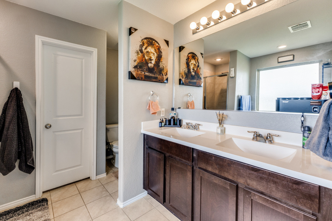 444 Major Lee Lane, Unit 14H Jarrell, TX 76537 - Photo 14 of 22 a bathroom with a sink and a mirror