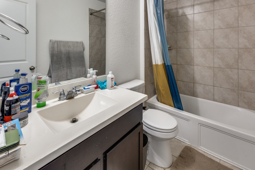 444 Major Lee Lane, Unit 14H Jarrell, TX 76537 - Photo 19 of 22 a bathroom with a sink a toilet and bathtub
