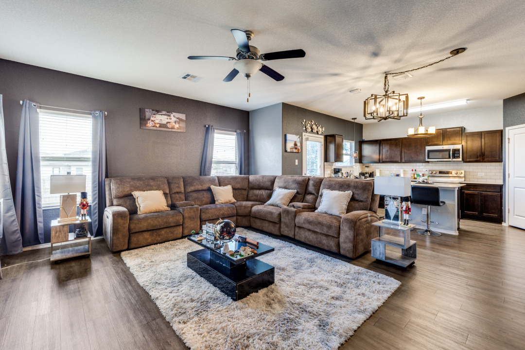444 Major Lee Lane, Unit 14H Jarrell, TX 76537 - Photo 5 of 22 a living room with furniture kitchen view and a chandelier