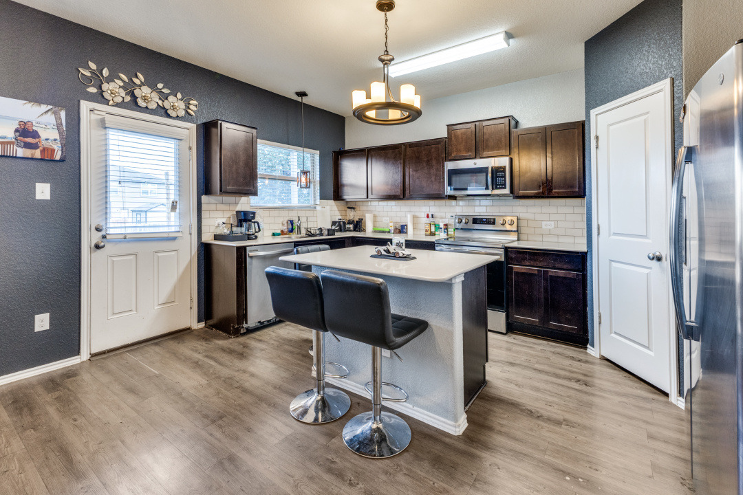 444 Major Lee Lane, Unit 14H Jarrell, TX 76537 - Photo 6 of 22 a kitchen with stainless steel appliances granite countertop a sink refrigerator stove and microwave