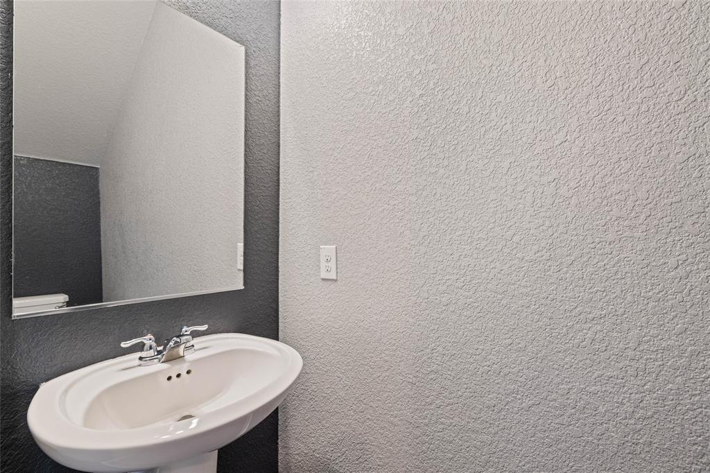 444 Major Lee Lane, Unit 14H Jarrell, TX 76537 - Photo 7 of 22 a bathroom with a sink and a mirror