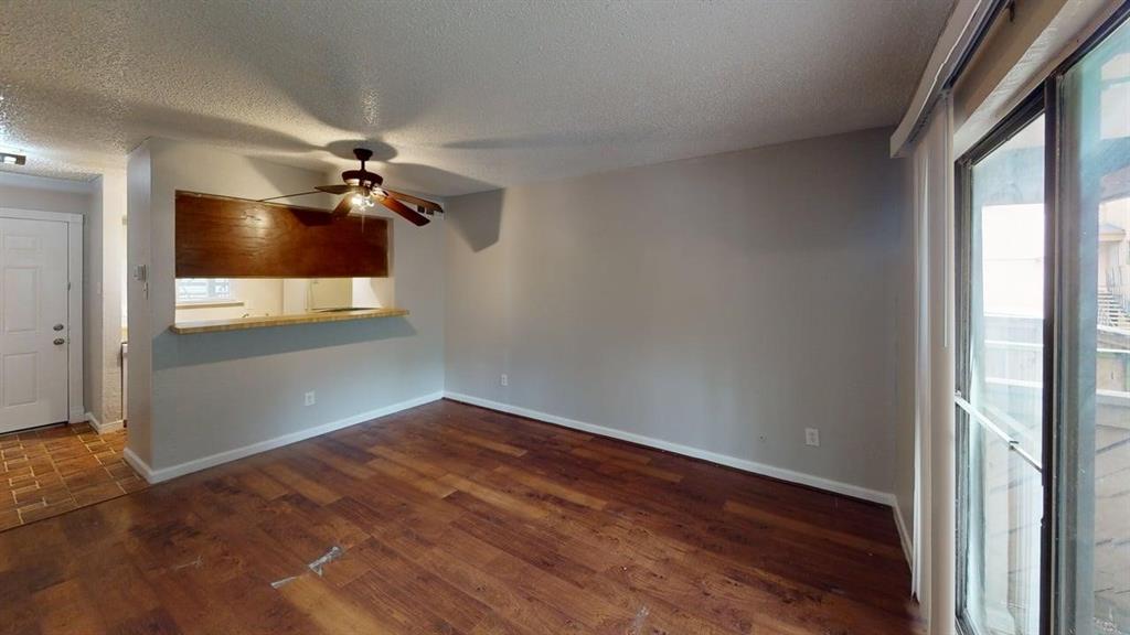 8110 Skillman Street, Unit 1016 Dallas, TX 75231 - Photo 3 of 12 Living area featuring wood-finish flooring, a ceiling fan, and sliding glass doors