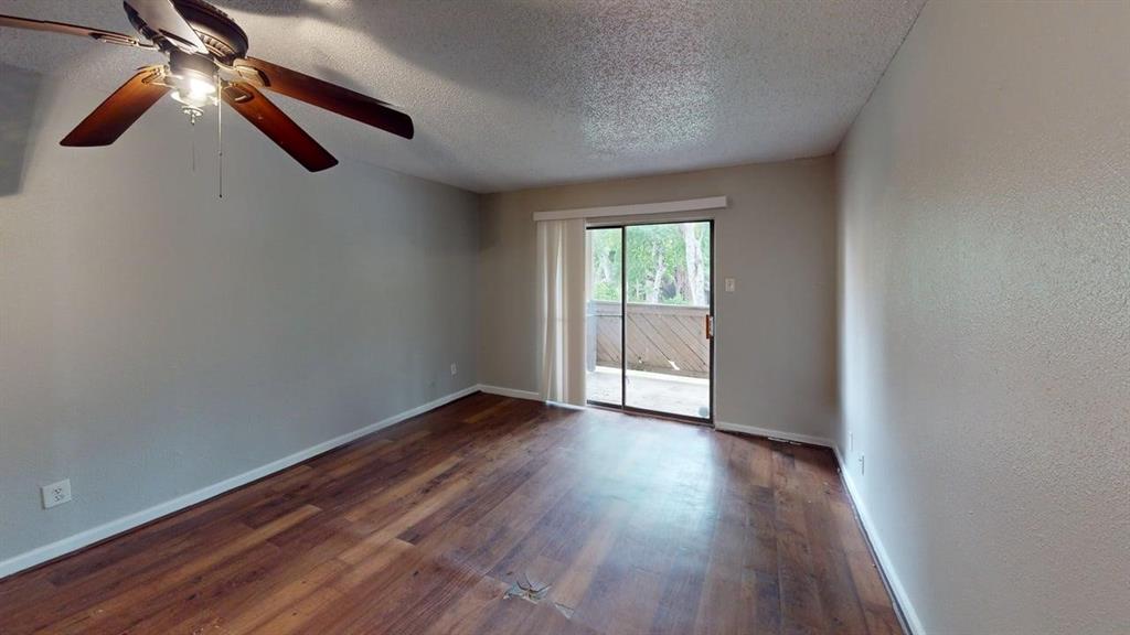 8110 Skillman Street, Unit 1016 Dallas, TX 75231 - Photo 5 of 12 Spacious interior featuring wood-finish flooring, neutral wall paint, and a ceiling fan with integrated lighting
