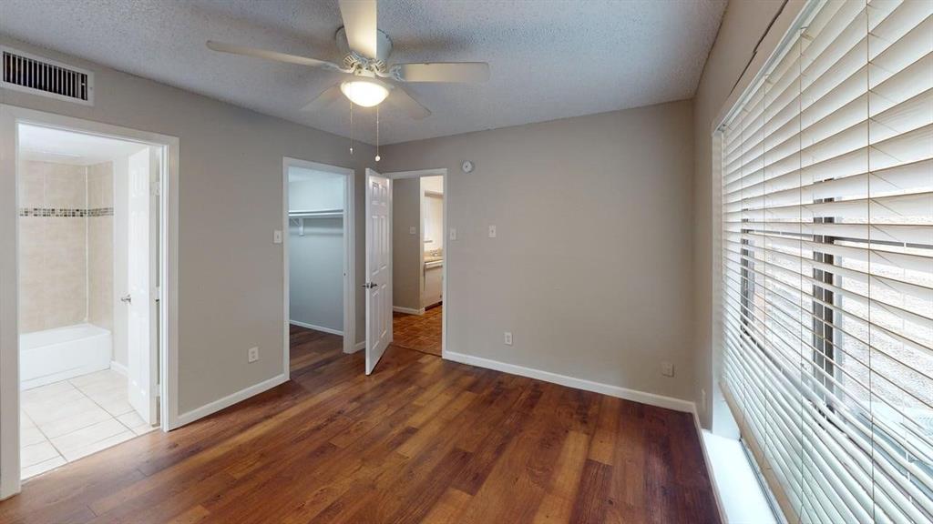 8110 Skillman Street, Unit 1016 Dallas, TX 75231 - Photo 6 of 12 Spacious room featuring wood-finish flooring, light gray wall paint, and a ceiling fan with integrated lighting