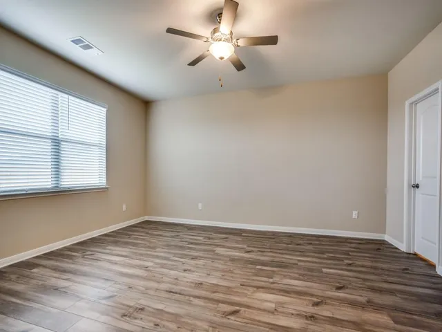 wooden floor in an empty room with a window