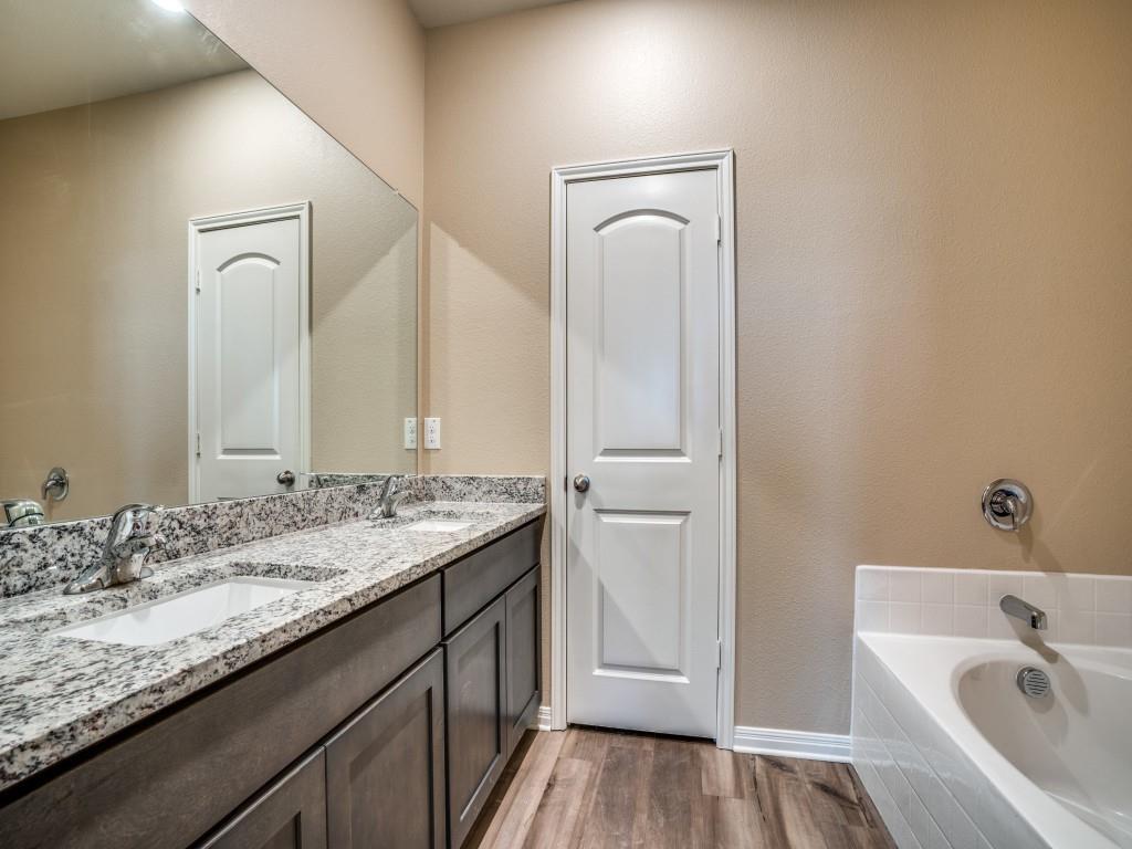 233 Enchanted Way Princeton, TX 75407 - Photo 13 of 25 a bathroom with a granite countertop sink a mirror and bathtub