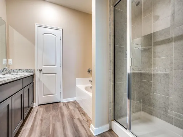 a bathroom with a granite countertop sink a toilet and shower