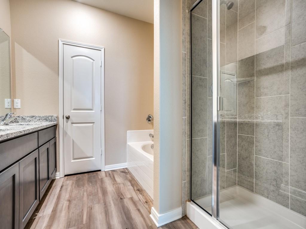 233 Enchanted Way Princeton, TX 75407 - Photo 15 of 25 a bathroom with a granite countertop sink a toilet and shower