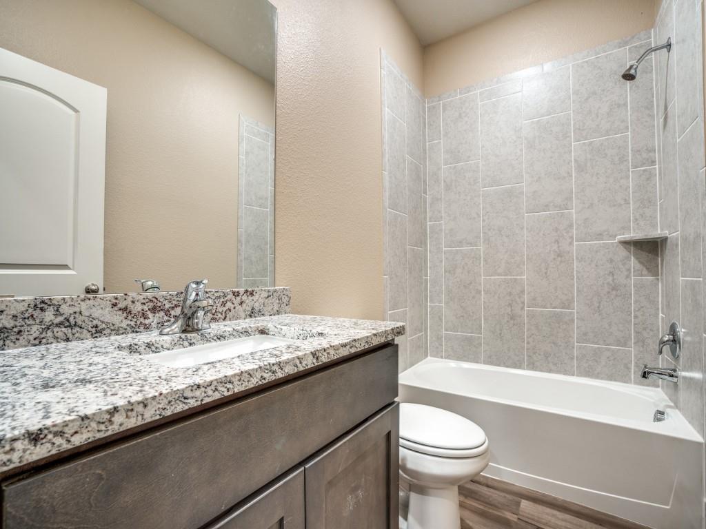 233 Enchanted Way Princeton, TX 75407 - Photo 20 of 25 a bathroom with a granite countertop sink a toilet a mirror and bathtub
