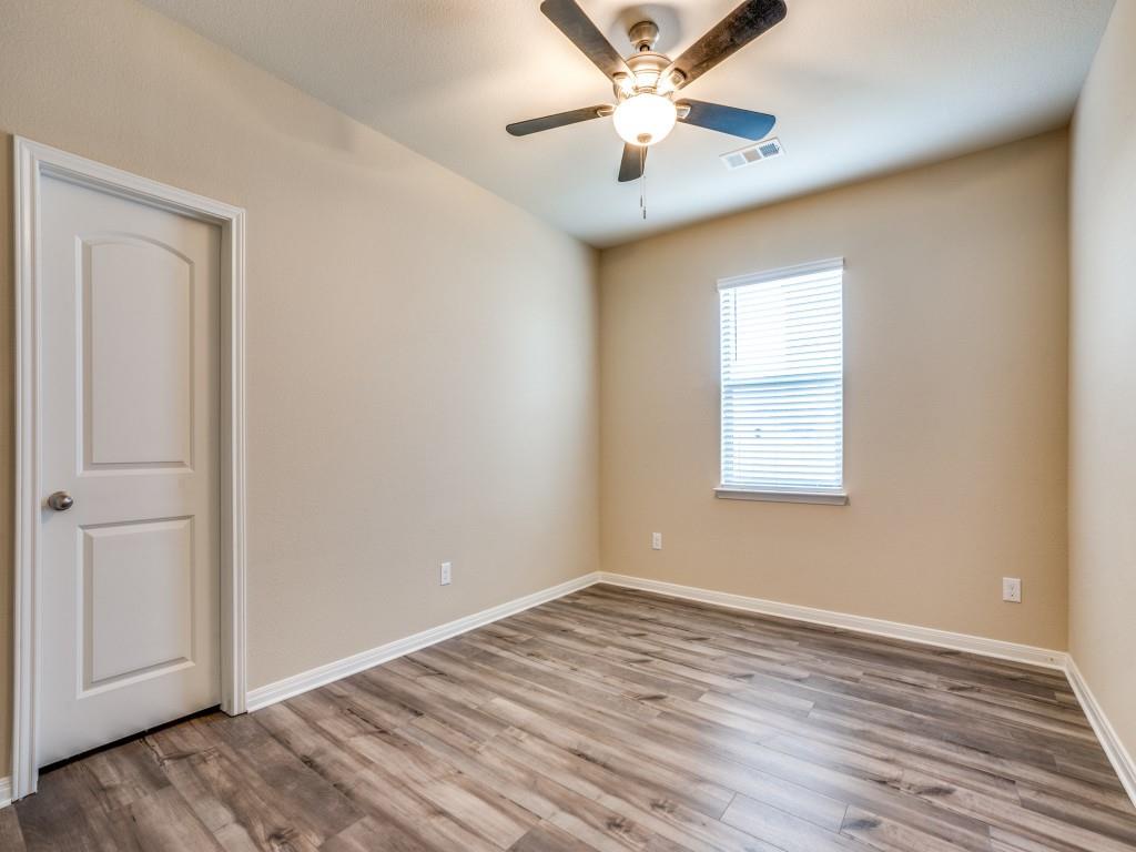 233 Enchanted Way Princeton, TX 75407 - Photo 21 of 25 an empty room with wooden floor chandelier fan and windows