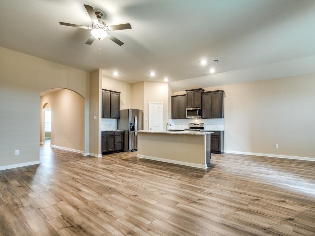 233 Enchanted Way Princeton, TX 75407 - Photo 7 of 25 a view of kitchen with refrigerator microwave and stove