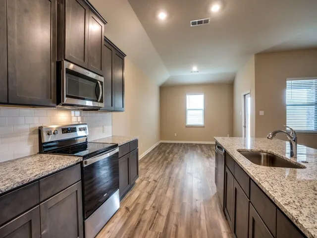 a kitchen with granite countertop stainless steel appliances and wooden cabinets
