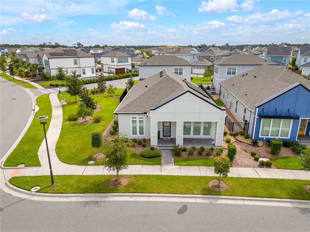 a aerial view of a house with a big yard and potted plants