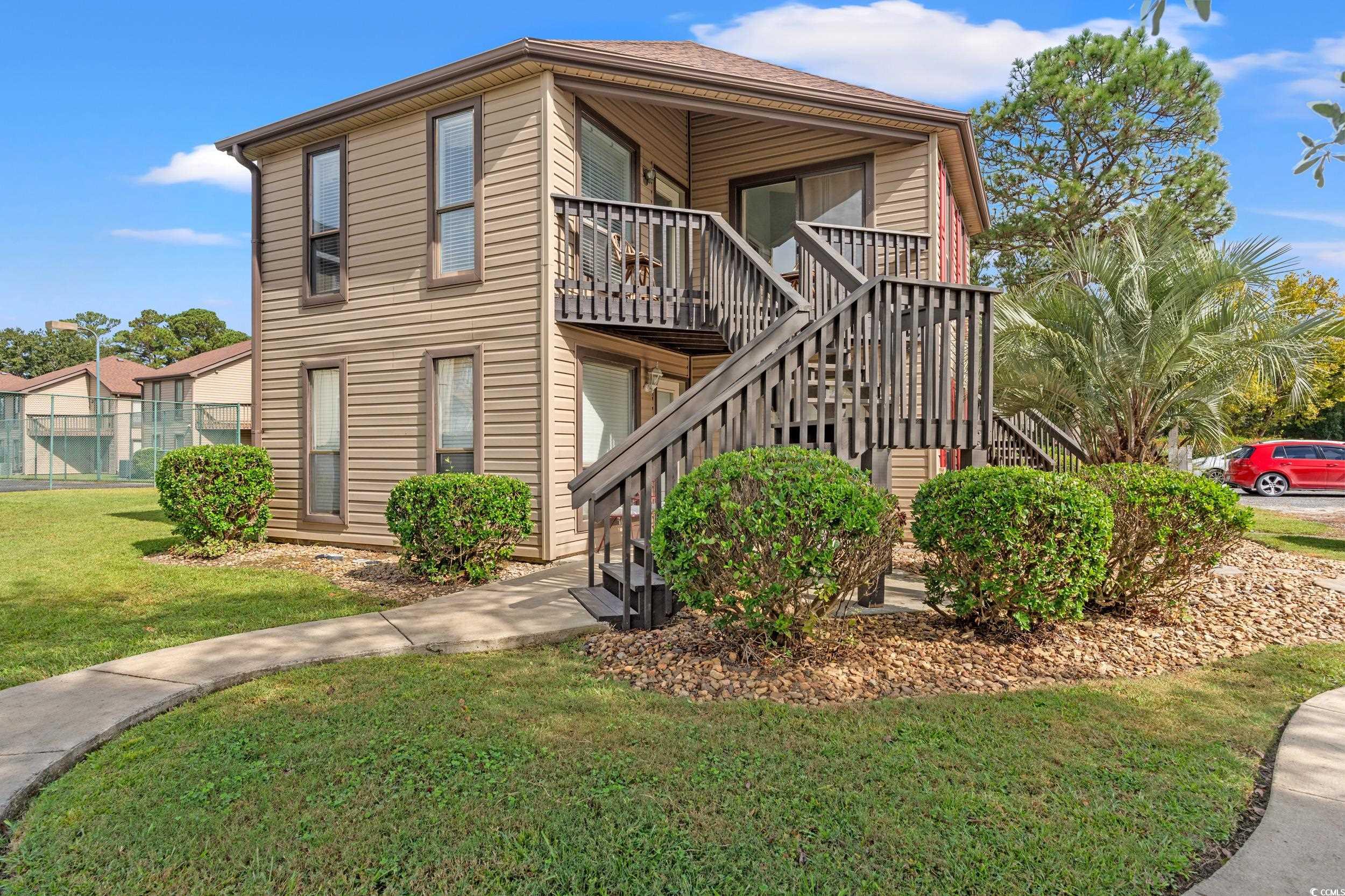 View of side of home with a yard and stairway