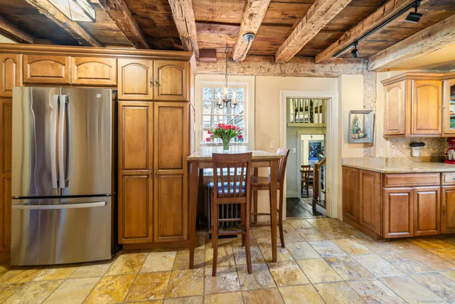 a kitchen with stainless steel appliances granite countertop a refrigerator and wooden cabinets