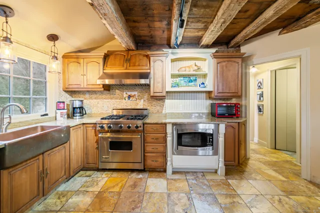 a kitchen with stainless steel appliances granite countertop a stove a sink and a refrigerator