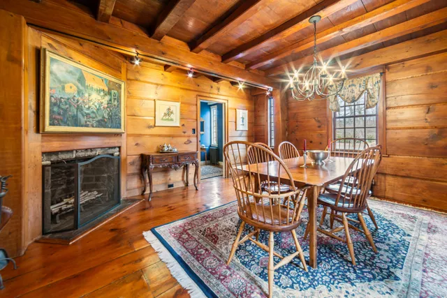 a dining room with furniture a chandelier and wooden floor