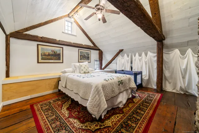 a bed sitting in a bedroom next to a window