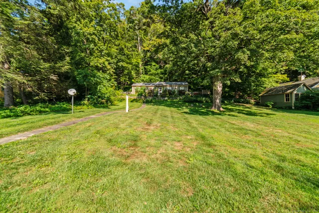 a view of green field with trees in the background