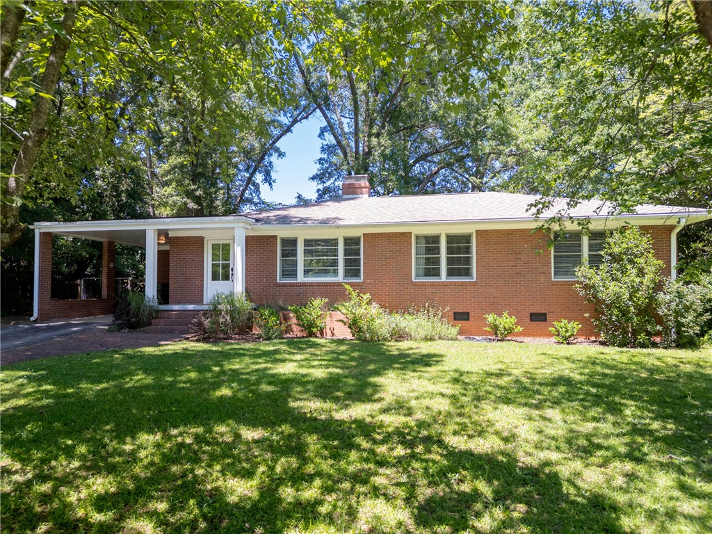 207 Brook Street Clemson, SC 29631 - Photo 1 of 39 A classic brick ranch home nestled among mature trees offers a welcoming facade with an attached carport.