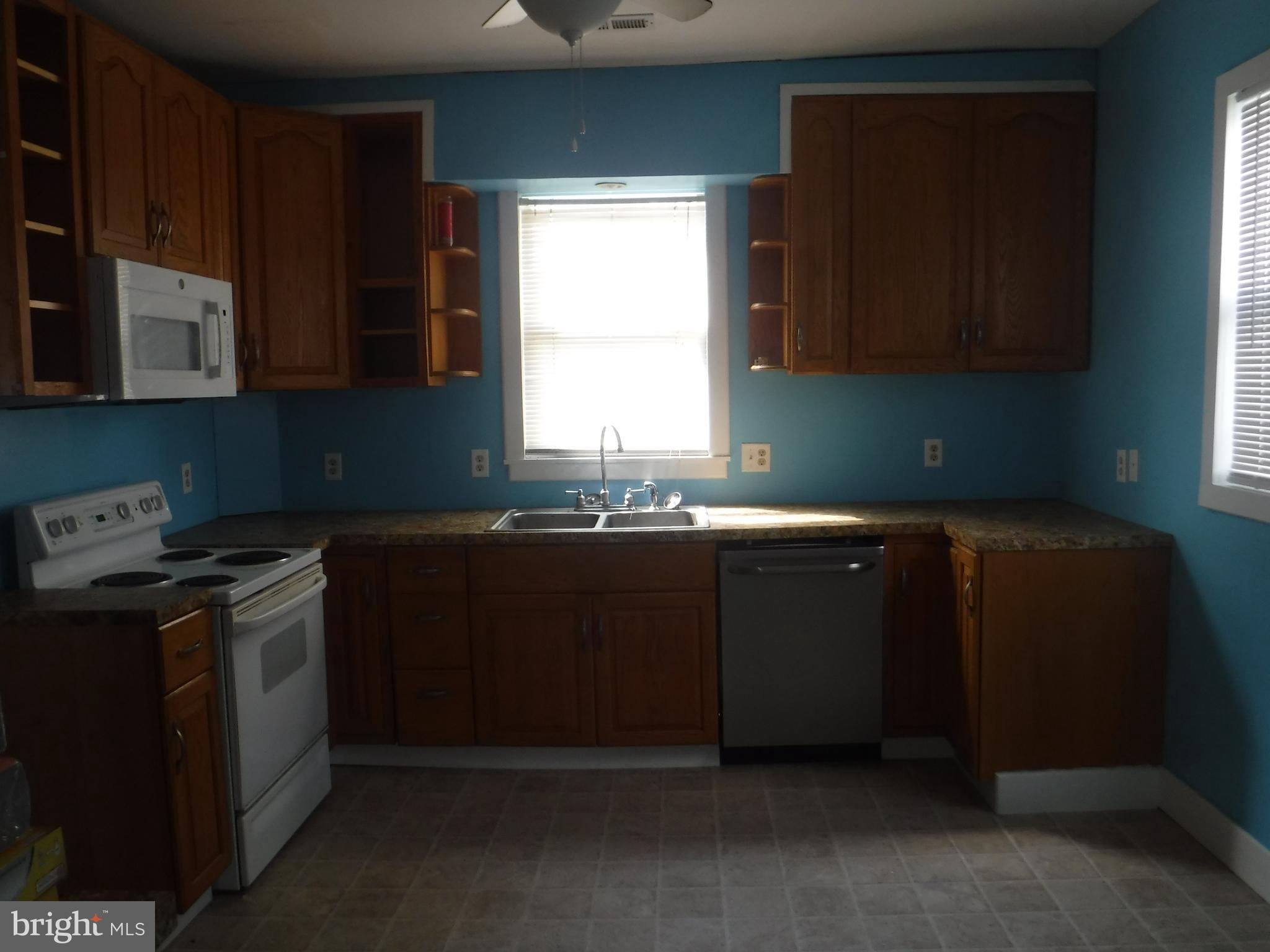 3 Mill Street Harrington, DE 19952 - Photo 5 of 25 a kitchen with granite countertop a stove a sink and a microwave