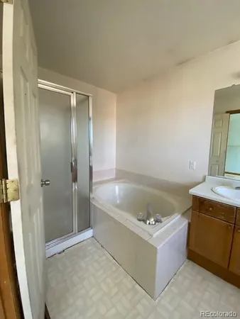 a bathroom with a tub a sink and a shower