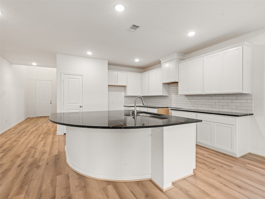 306 Strm Bnd Way Rosenberg, TX 77471 - Photo 12 of 35 a kitchen with granite countertop a sink and a stove top oven