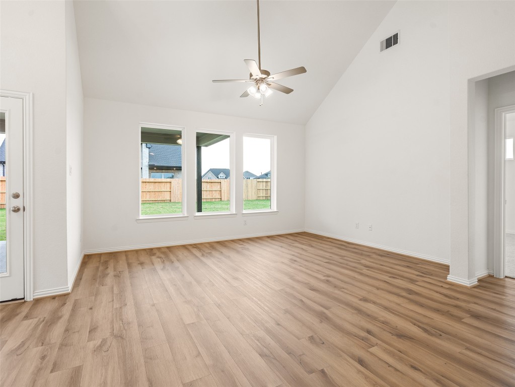 306 Strm Bnd Way Rosenberg, TX 77471 - Photo 15 of 35 an empty room with wooden floor chandelier fan and windows