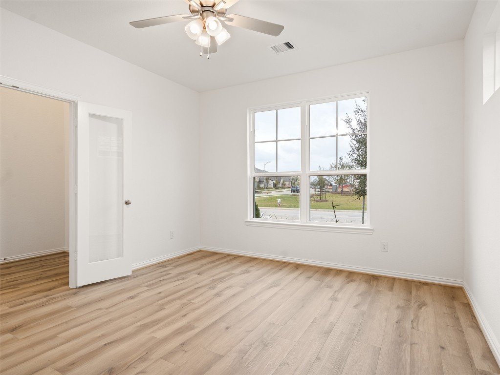 306 Strm Bnd Way Rosenberg, TX 77471 - Photo 6 of 35 an empty room with wooden floor and windows
