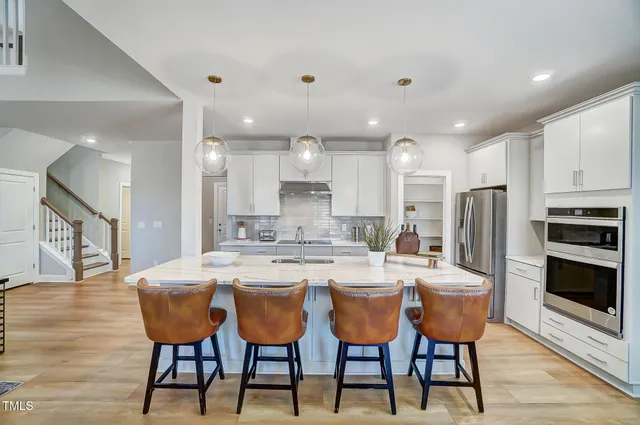 a large kitchen with a table and chairs