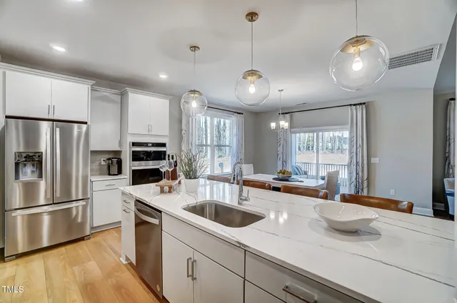 a kitchen with stainless steel appliances granite countertop a sink a stove and refrigerator