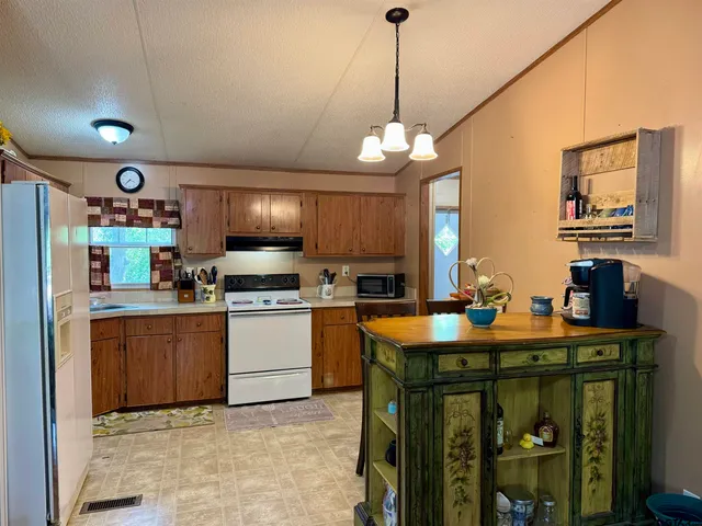 a kitchen with stainless steel appliances granite countertop a sink a stove and a refrigerator