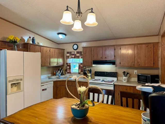 a kitchen with stainless steel appliances granite countertop a stove refrigerator a sink dishwasher and a microwave