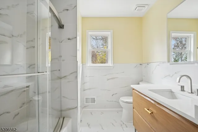 a bathroom with a sink a toilet and shower