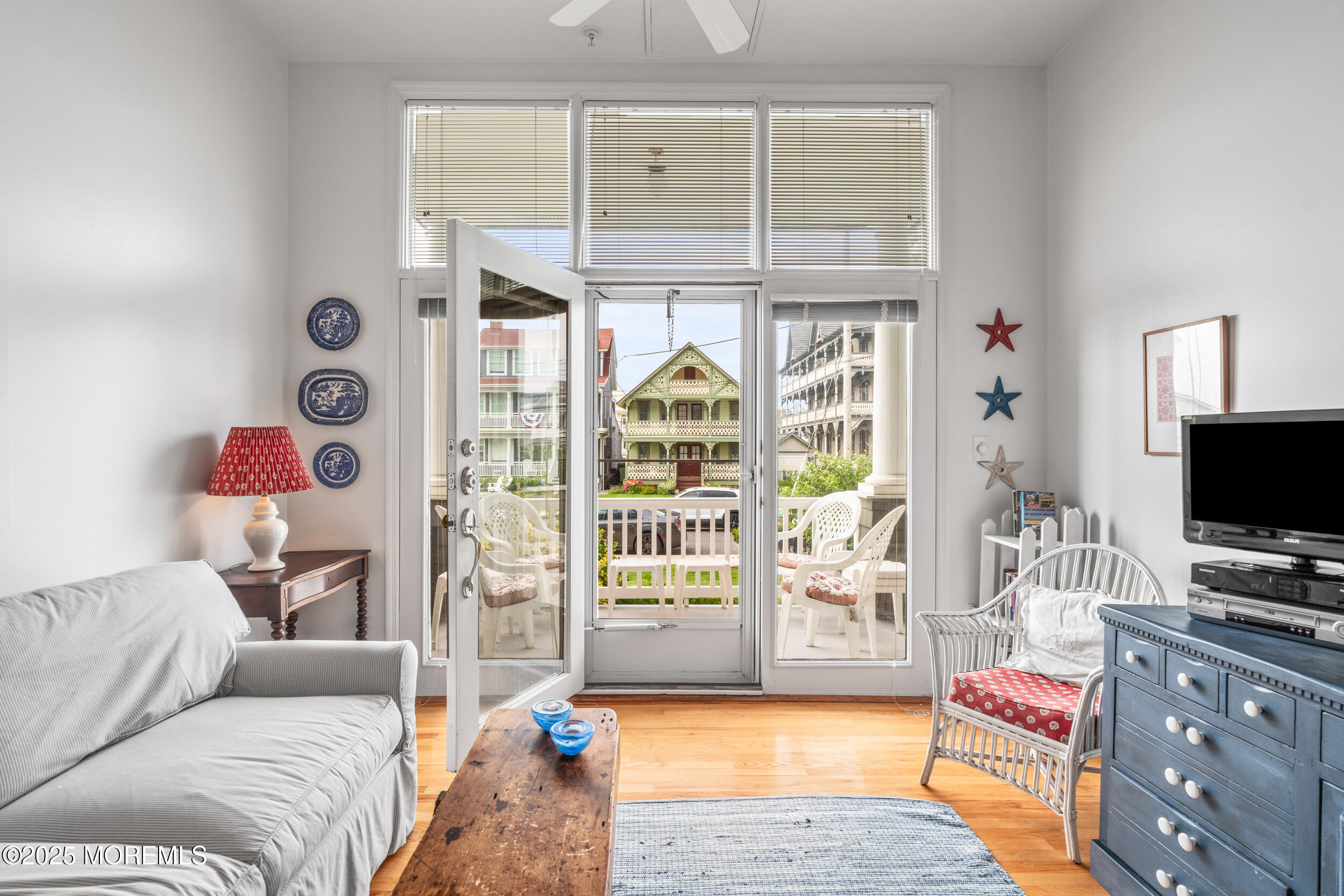 4 Ocean Avenue, Unit 5 Ocean Grove, NJ 07756 - Photo 23 of 81 a living room with furniture a flat screen tv and a floor to ceiling window