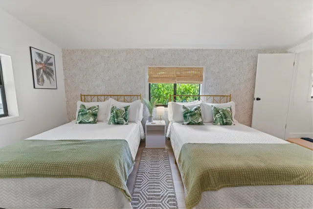 a bedroom with two beds and a large window