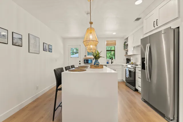 a kitchen with stainless steel appliances a refrigerator sink and wooden floor