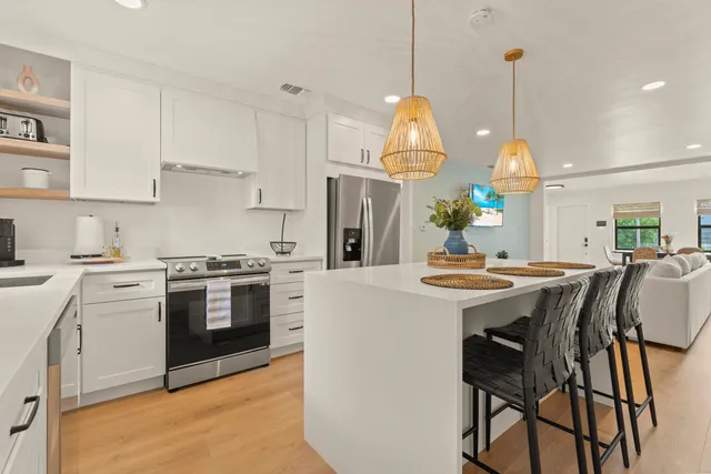 a kitchen with stainless steel appliances kitchen island a table and chairs in it