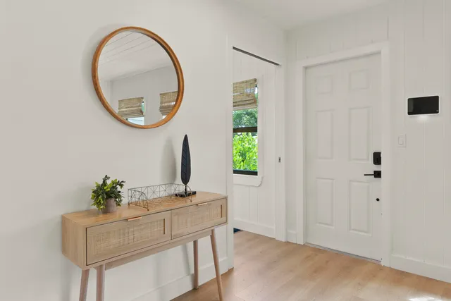 a view of a room that has a mirror and a plant in it