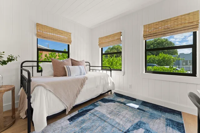 a bedroom with a bed and a large window with outer view