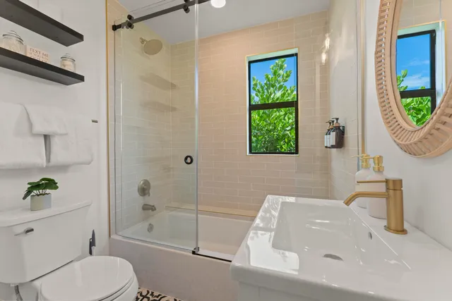 a bathroom with a sink a toilet and shower