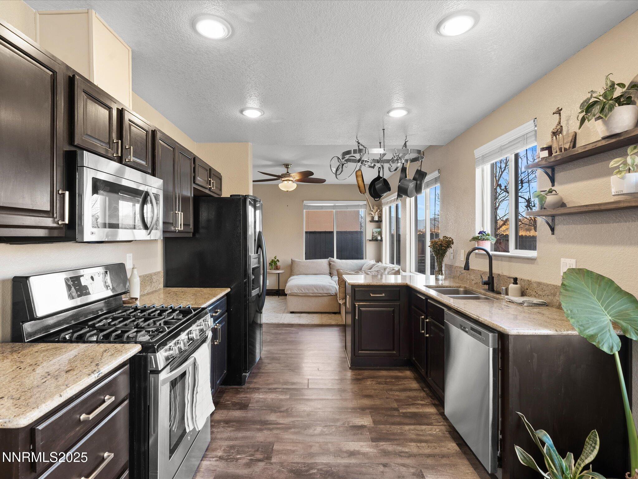 7227 Heatherwood Drive Reno, NV 89523 - Photo 21 of 55 a kitchen with stainless steel appliances granite countertop a sink stove and refrigerator