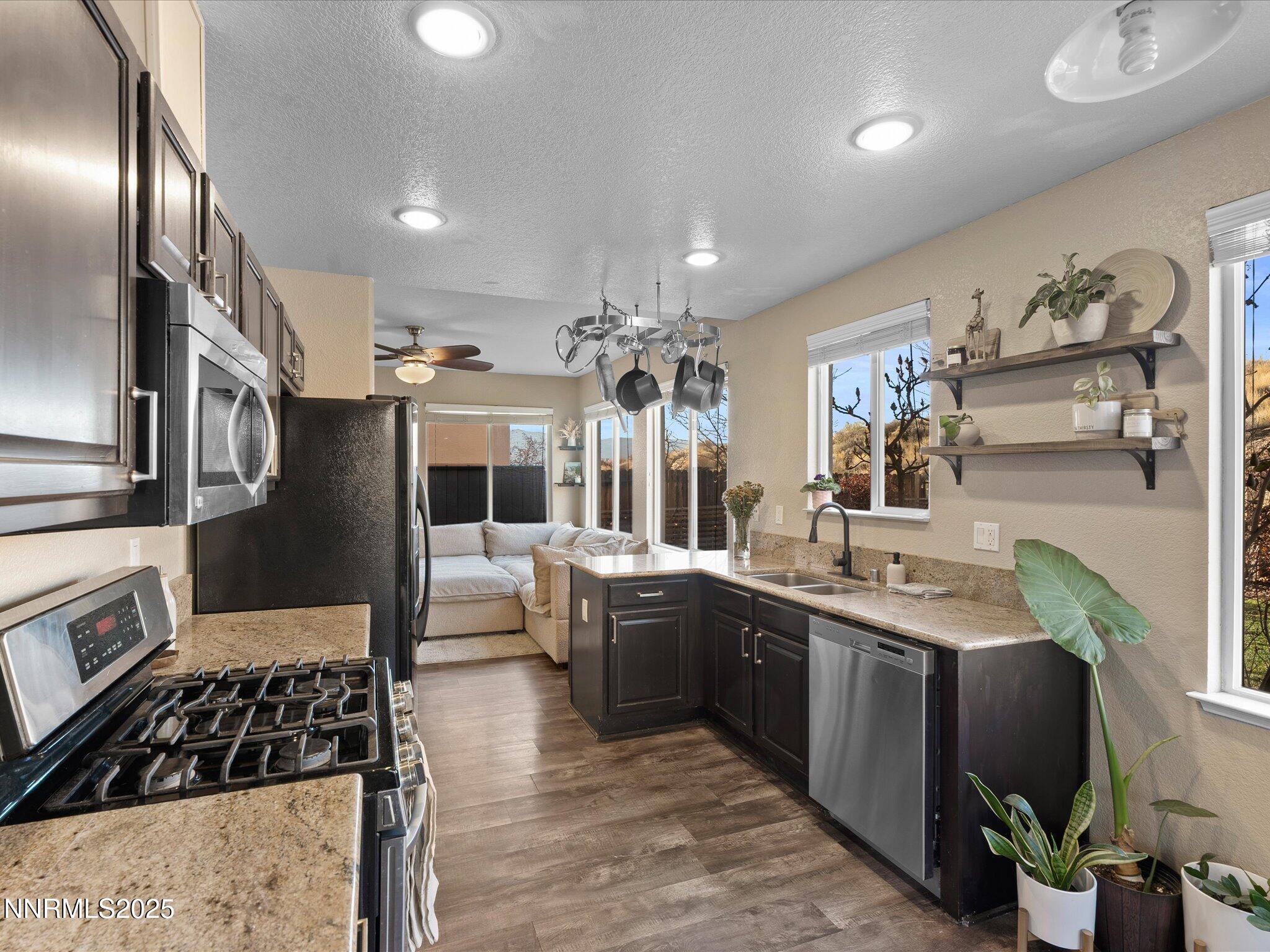 7227 Heatherwood Drive Reno, NV 89523 - Photo 22 of 55 a kitchen with stainless steel appliances kitchen island granite countertop a sink and cabinets