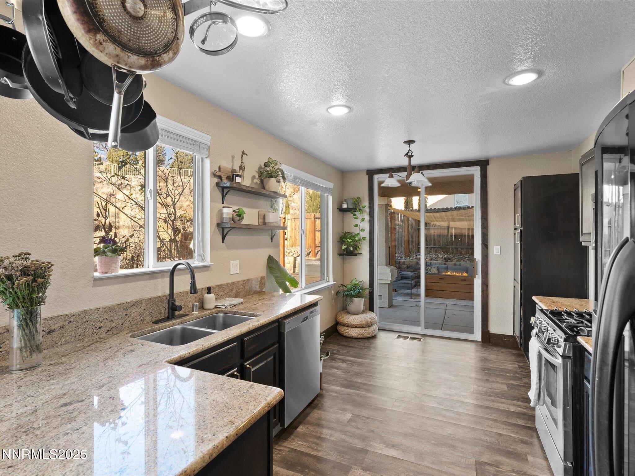 7227 Heatherwood Drive Reno, NV 89523 - Photo 24 of 55 a kitchen with stainless steel appliances granite countertop a sink a stove and a refrigerator