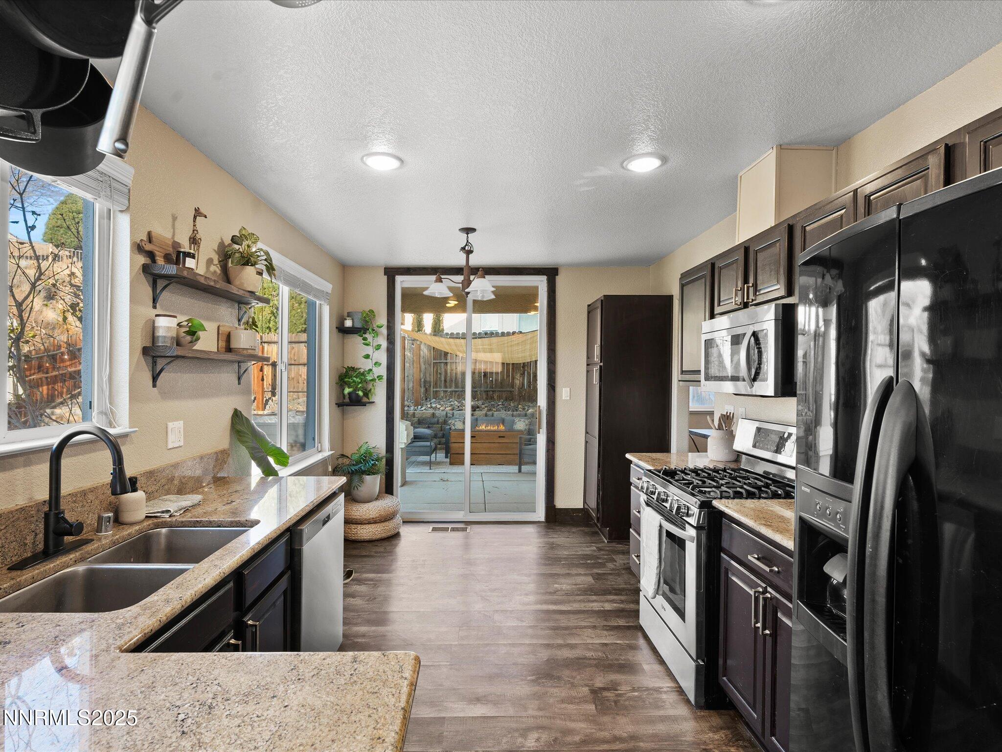 7227 Heatherwood Drive Reno, NV 89523 - Photo 25 of 55 a kitchen with stainless steel appliances granite countertop a sink stove and refrigerator