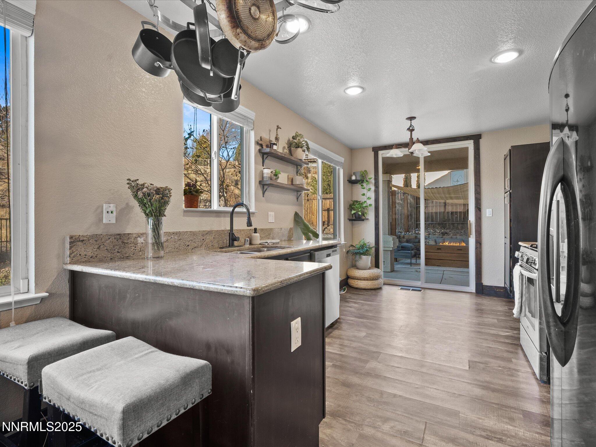 7227 Heatherwood Drive Reno, NV 89523 - Photo 26 of 55 a kitchen with stainless steel appliances granite countertop a sink and a refrigerator