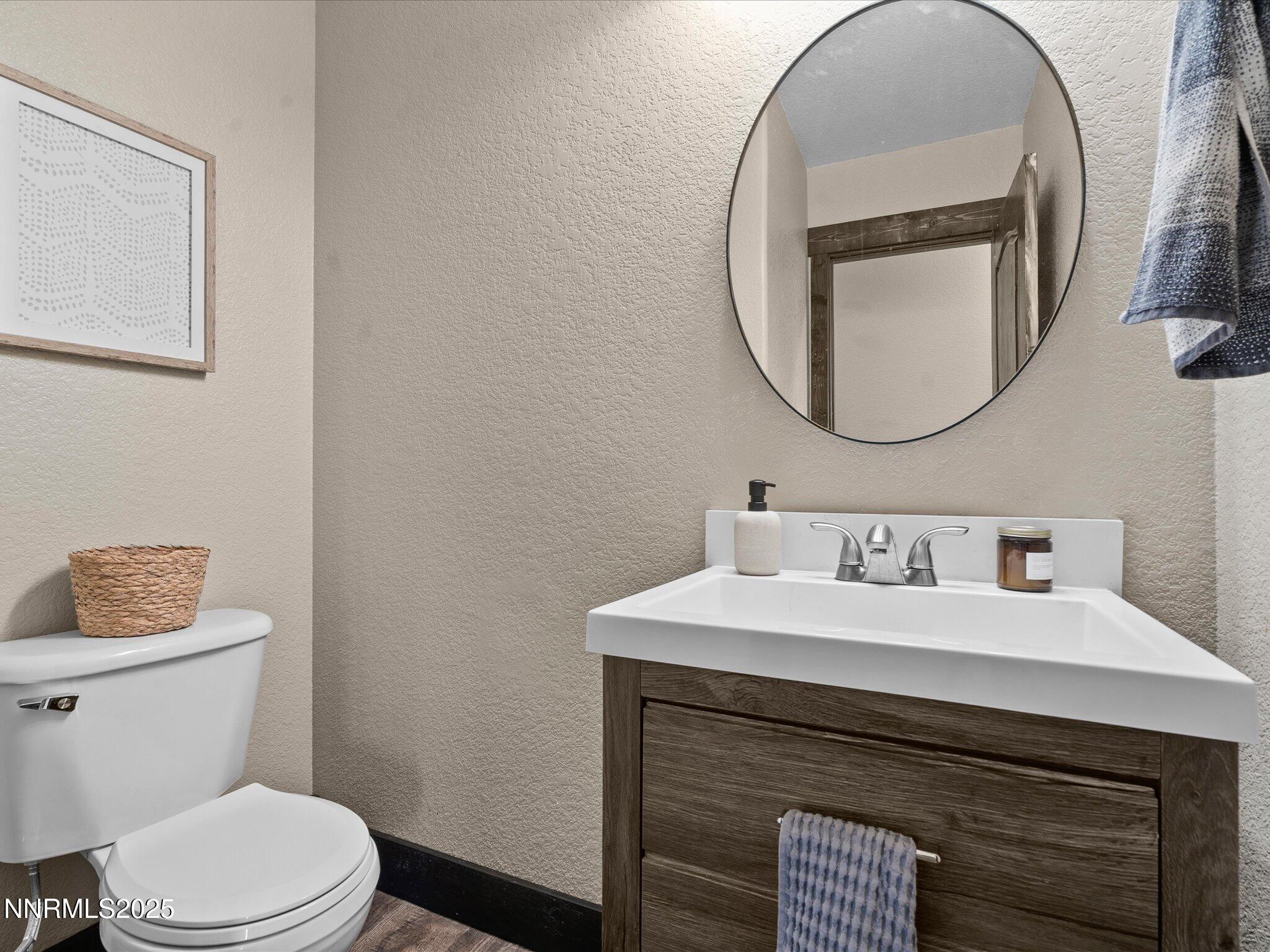 7227 Heatherwood Drive Reno, NV 89523 - Photo 31 of 55 a bathroom with a toilet sink vanity and mirror